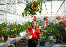 Viktoriia Taranenko in the greenhouse full of fruit and vegetable plants for the kitchen and garden.