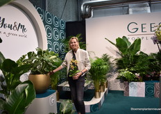 Esther van Geest with the Phalaenopsis mulit, a yellow trident. Besides the orchid, they also present many green plants.