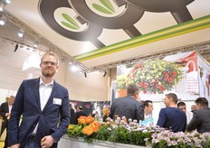 Jan Grünewald of Grünewald Breeding. He is standing next to the Red Gold Dahlia Stralias. This is a new variety in the Dahlia Stralias series. According to Grünewald, the intense color is what makes it a popular variety.