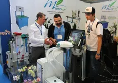 Evan Kakouros (middle) from Australia, gets a demonstration of how the new MecaFlor packaging machine works