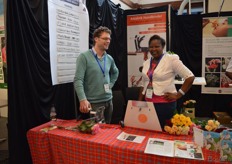 Floris Muilwijk of UFO Supplies and Fridah Kabiritu of Red Lands Roses talking about the Flower Binding Contest. Participants had to bind six bunches of flowers together. The time it time it takes was registered on the board behind Floris.