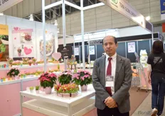 Eiji Kageyama iof Nanahoshi standing next to the Poinsettia of Suntory. Nanahoshi is a Japanese company that buys Japanese plants and flowers and sells them in Japan.