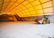 A big Caterpillar shovel truck is transporting chips non stop from the storage towards the biomass boilers. This barn can store enough wood chips to heat the greenhouse for two weeks.