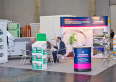 Soren Schumann from Schumann Screening in his booth in conversation with customers.