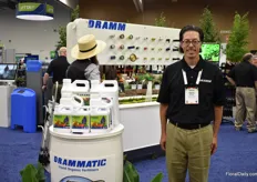 Hans Dramm of Dramm Corporation next to the Drammatic liquid fertiliser and in in front of their water accessories display.
