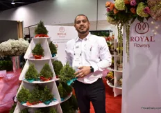 David Sanchez of Royal Flowers presenting one of their new Ecuadorian grown tree trimmings. "We trim the trees that are grown at our farm and shape it into a Christmas tree, so no trees are being cut down." They are handmade at their bouquet operation and can last for one month without water. They sell it with the display